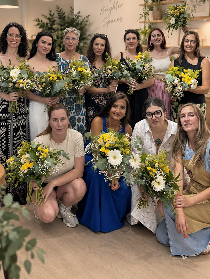 Participantes mostrando los ramos creados durante un workshop floral para empresas