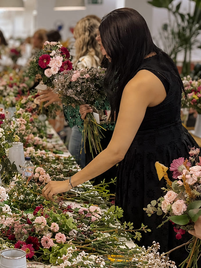 Participante trabajando entre flores frescas durante un taller floral
