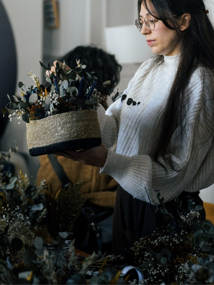 Participante creando una composición con flores preservadas durante un workshop