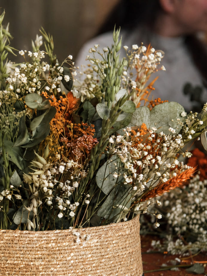 Detalle de composición realizada con flores preservadas en tonos naturales y naranja