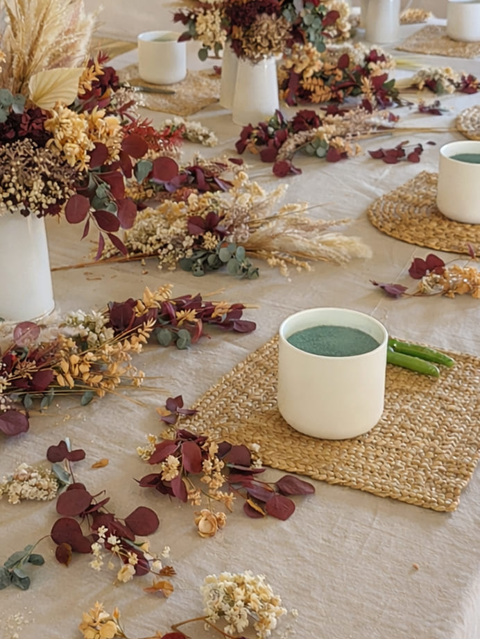 Mesa de trabajo con flores preservadas y materiales para crear una composición floral