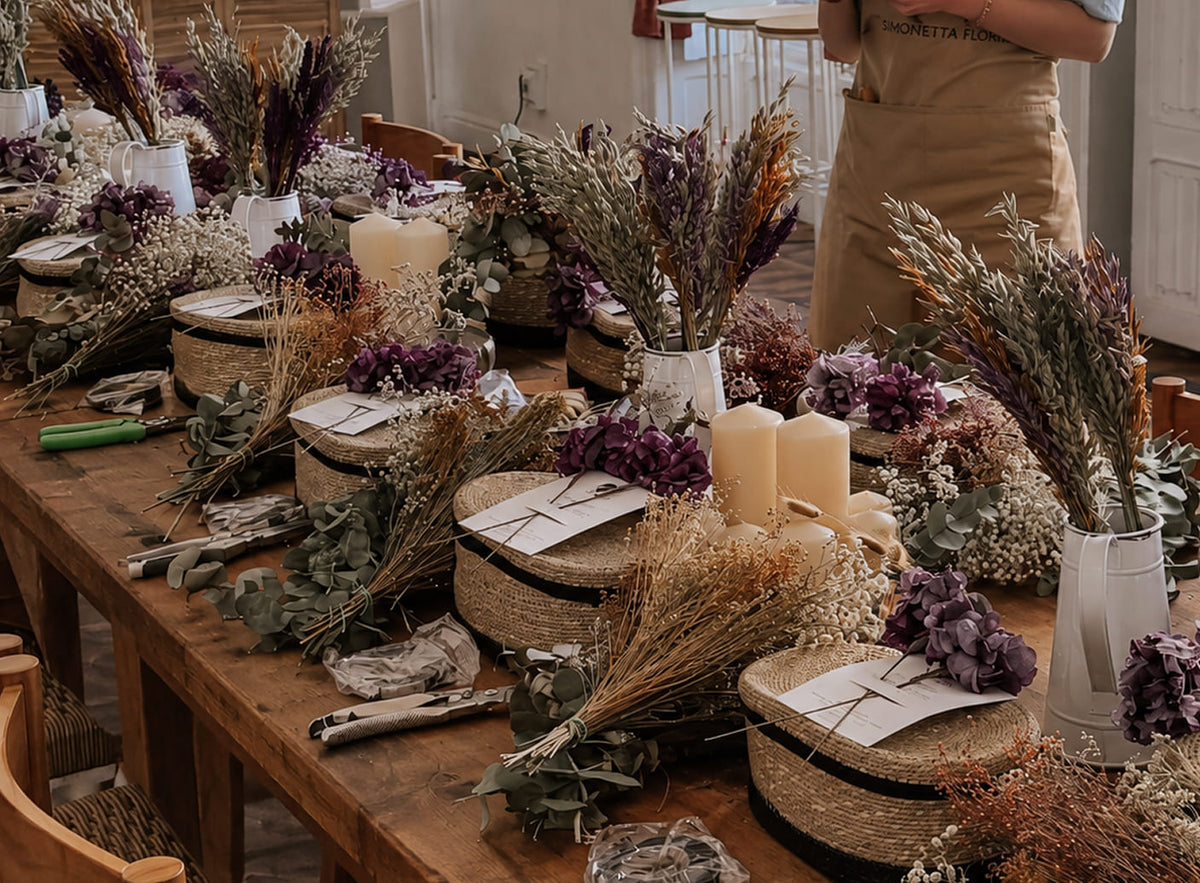 Mesa preparada con flores preservadas y materiales para un workshop floral