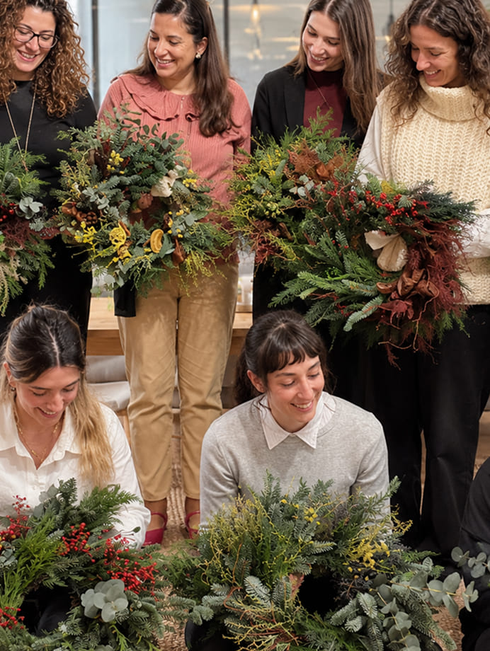 Grupo de participantes mostrando sus coronas en un taller de Navidad para empresas