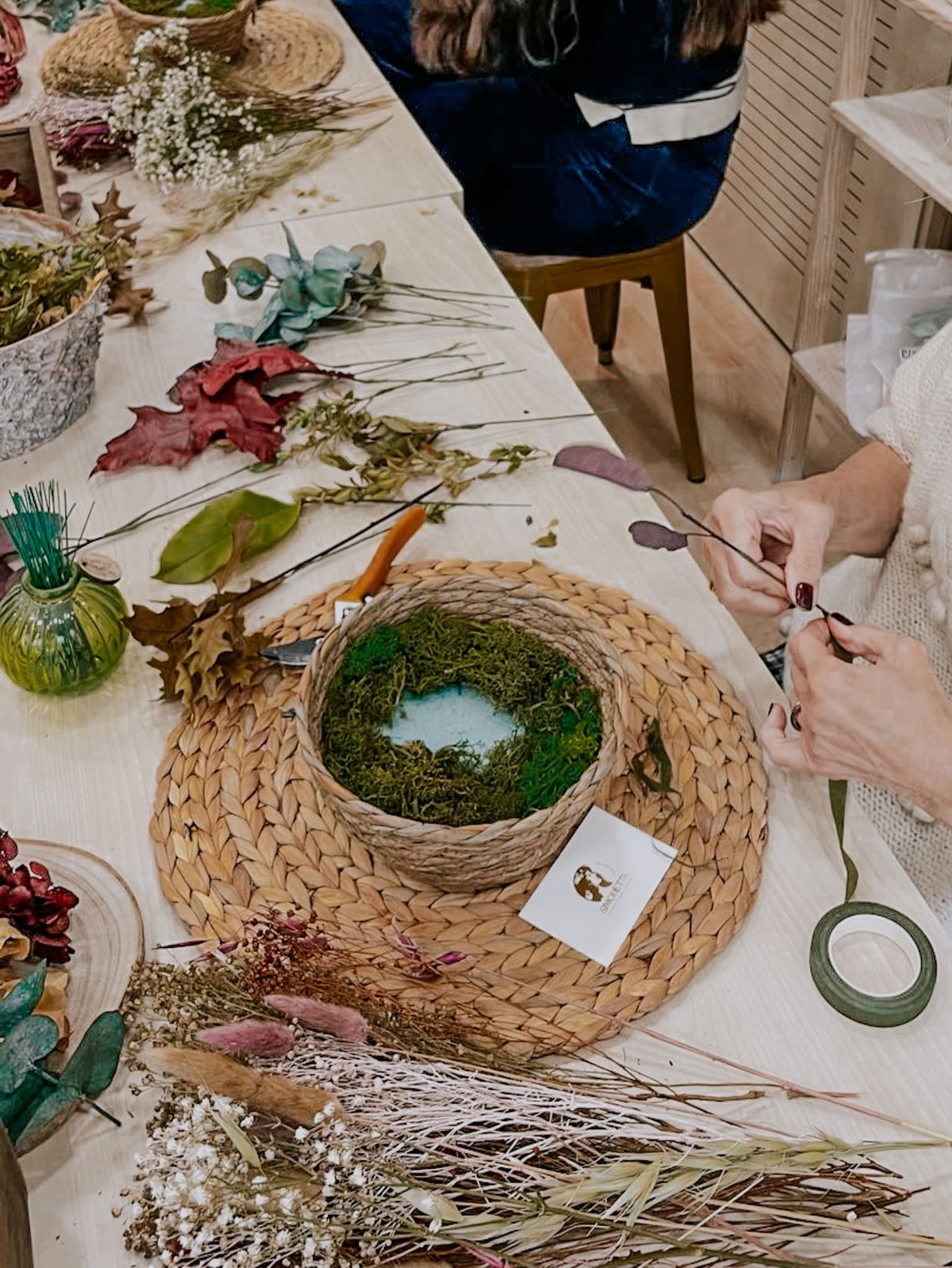 Mesa donde se está realizando un taller de flores preservadas