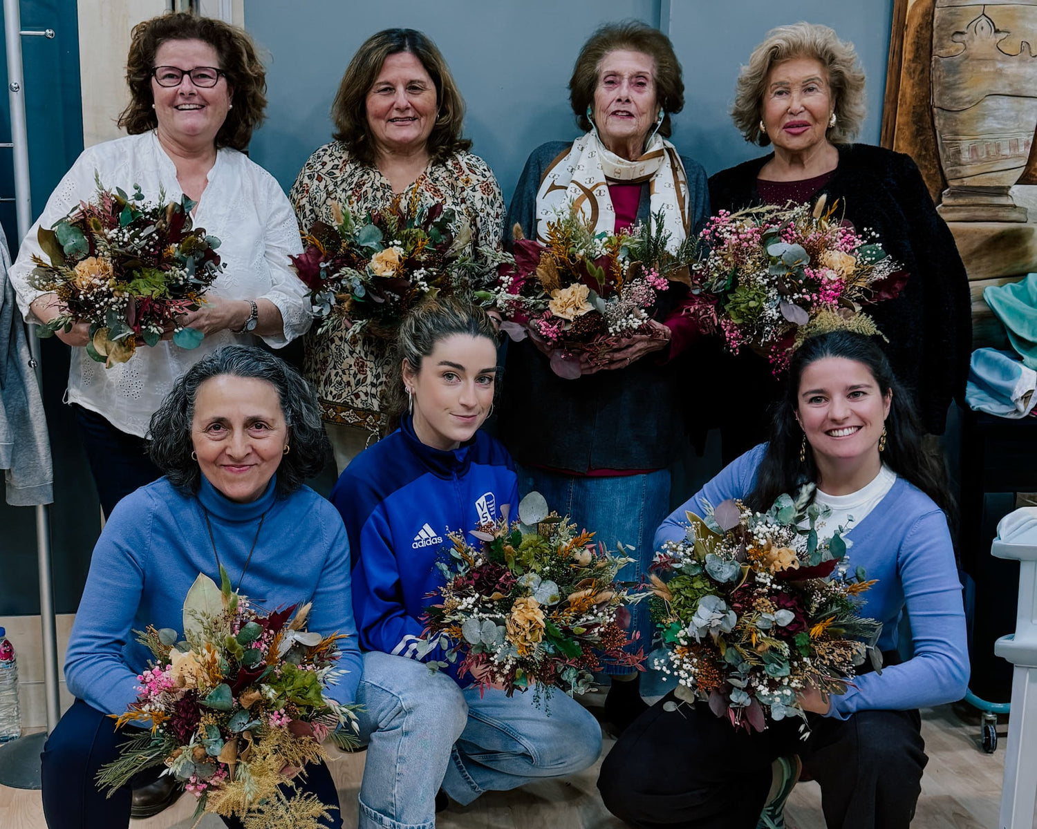 Una familia mostrando el resultado de sus centros de flores preservadas